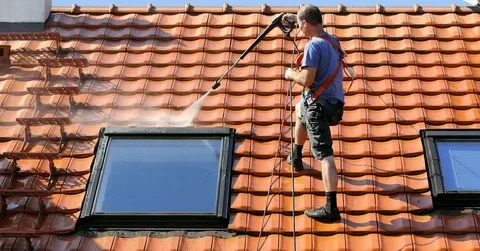 The skilled roofer is providing roof cleaning services as an integral part of our Round Rock, TX Roof Replacement Services.