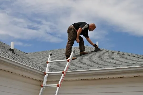 A roofing contractor is inspecting the roof before work in Leander, TX