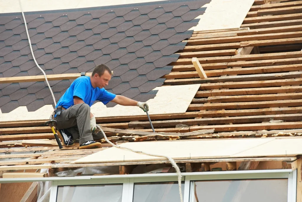 The worker is performing shingle roof repair in Manor, TX