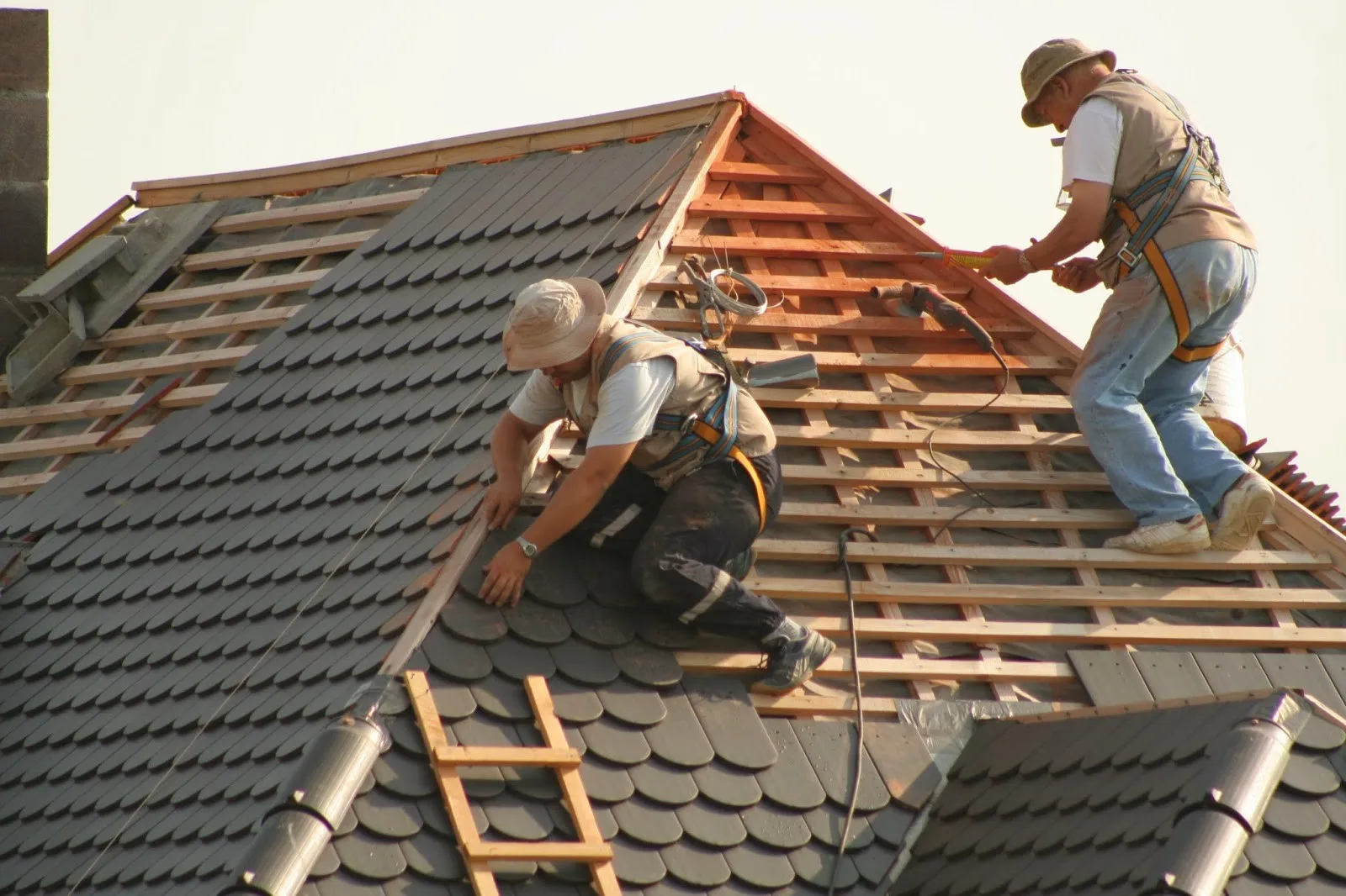 Two roofers are working on the installation of the roof in Cedar Park, TX