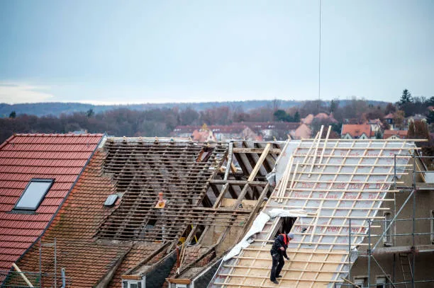 A professional roofer performing roof replacement services on a residential home in Hutto, TX.